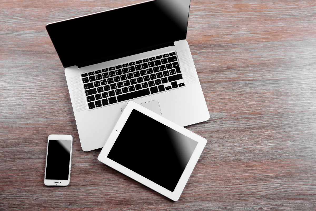 ordinateur portable et tablette posé sur un bureau en bois
