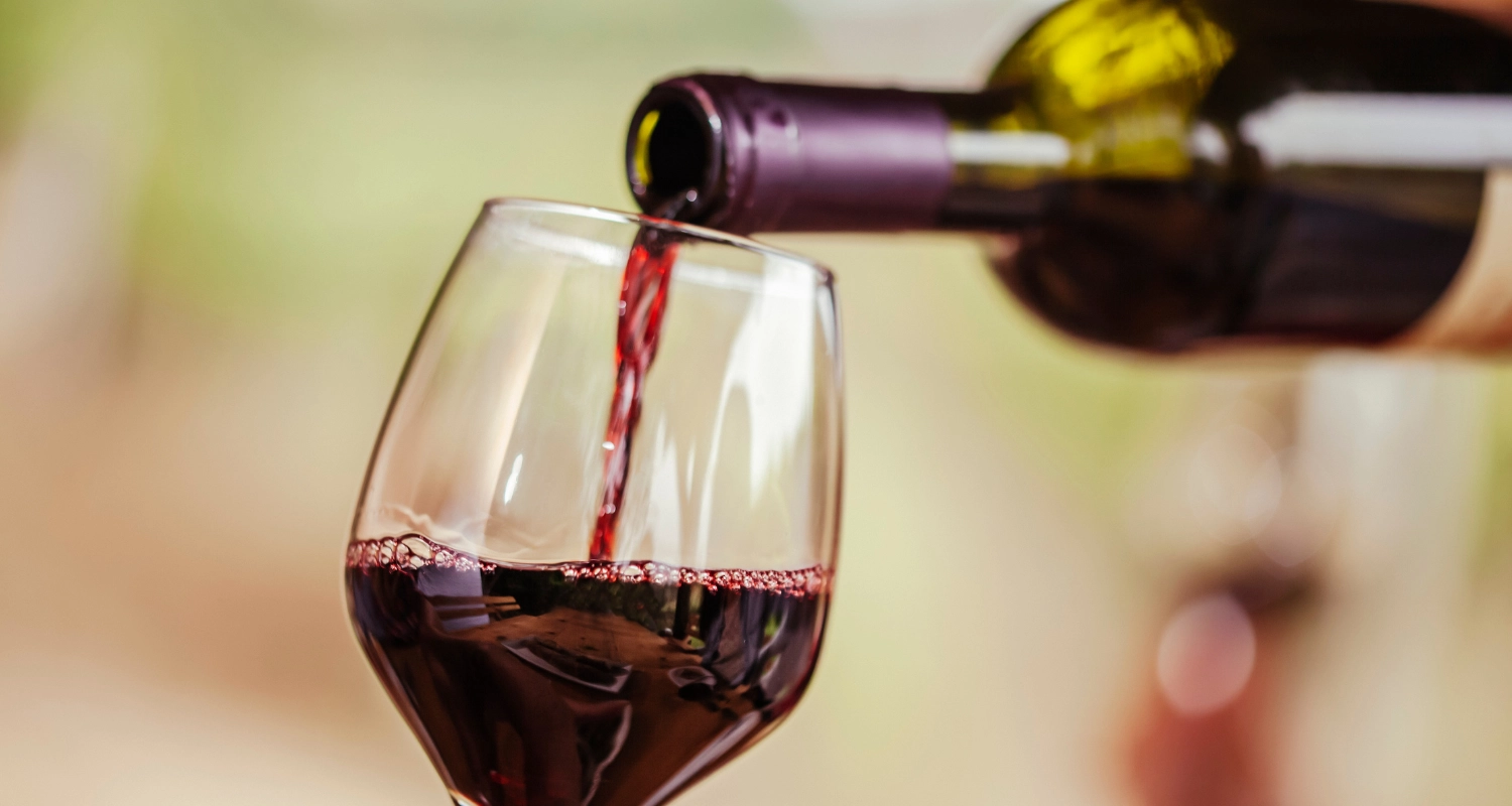 Coupe avec vin rouge qui est versé à l'intérieur.
